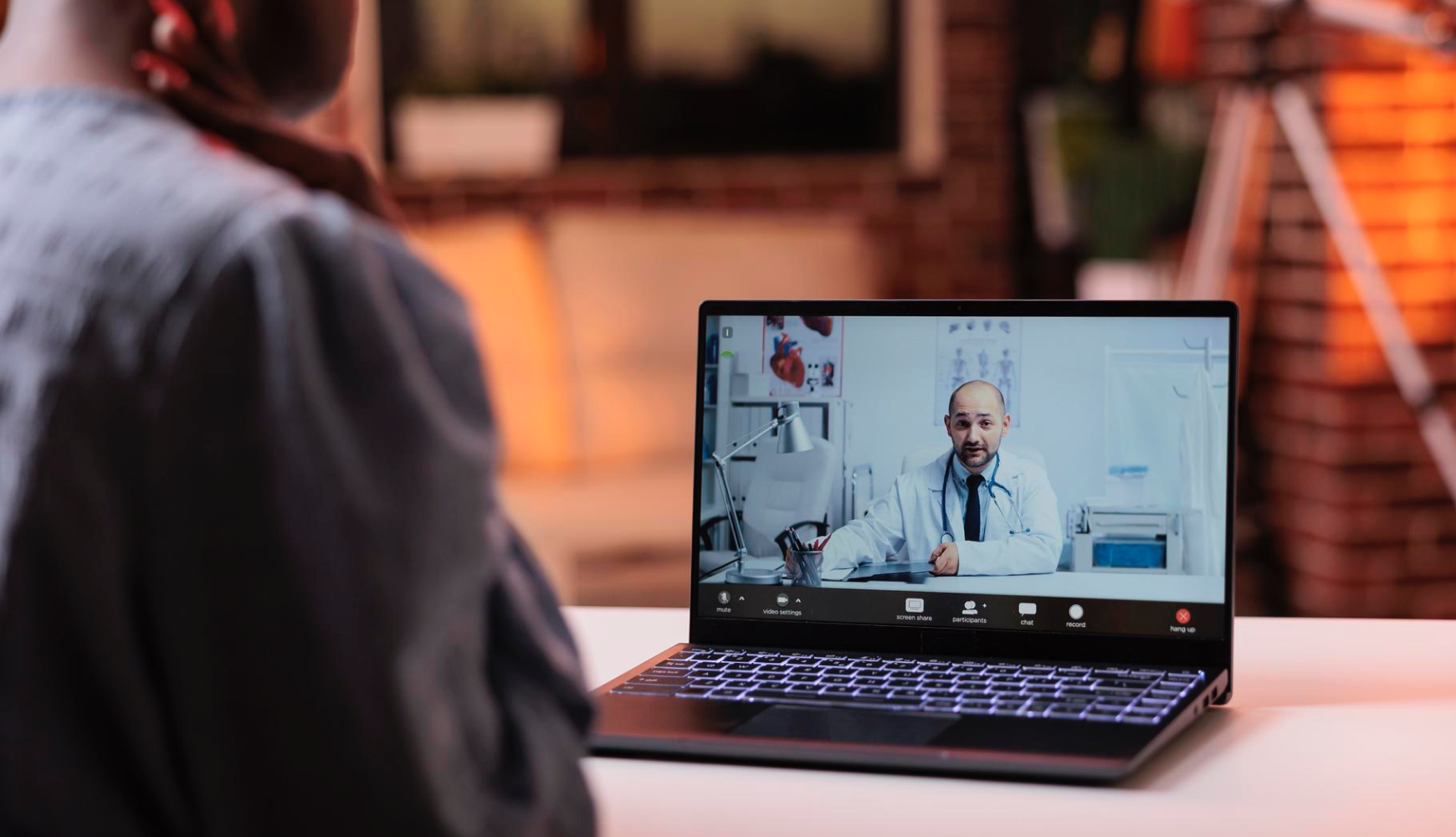 Telehealth consultation with a doctor via laptop, showcasing faster adoption of new technology as a key benefit of outsourcing IT services in healthcare.