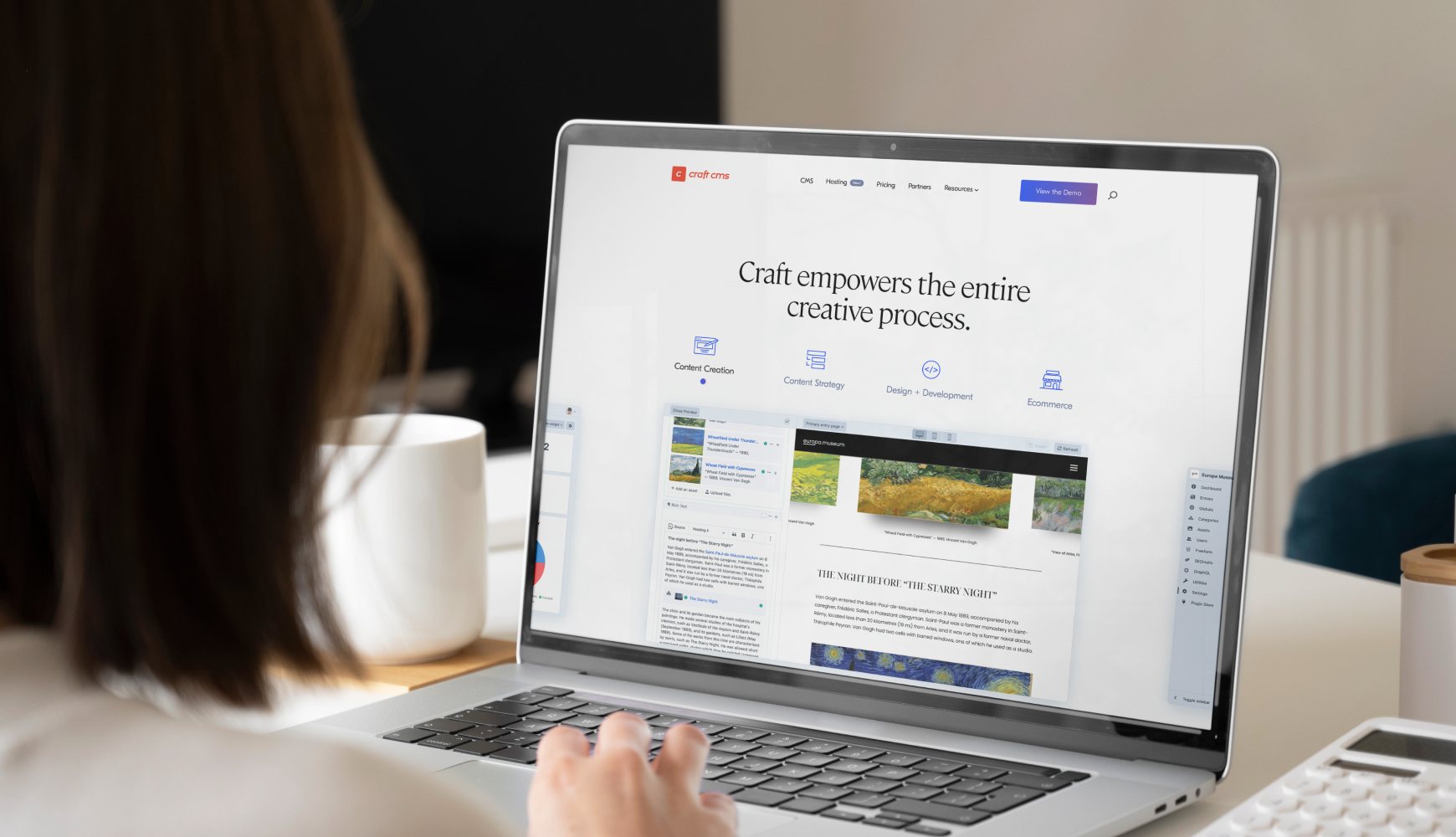 A woman focused on her laptop, designing a website, comparing Joomla vs Craft CMS for optimal content management.