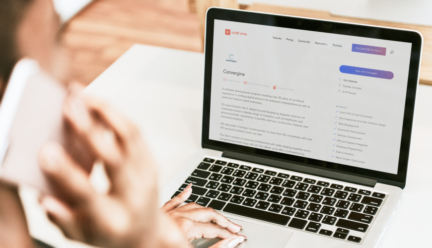 Individual working on a laptop, focusing on a resume, highlighting their status as a Verified Craft CMS Partner.